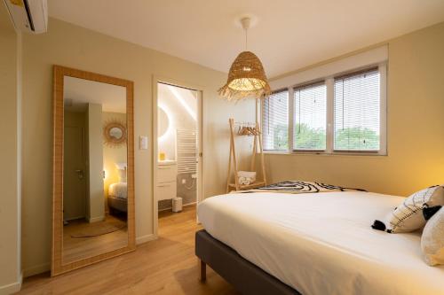 a bedroom with a large bed and a mirror at Air Nomad • Bali in Valenciennes