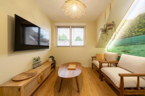 a living room with a couch and a tv at Air Nomad • Bali in Valenciennes