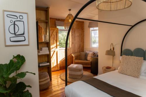 a bedroom with a bed and a living room at Stoep By Ideas Cartel in Kalk Bay