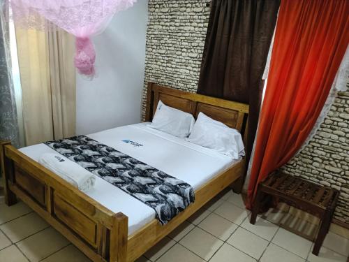 a bedroom with a bed and a red curtain at Escape Retreats in Diani Beach