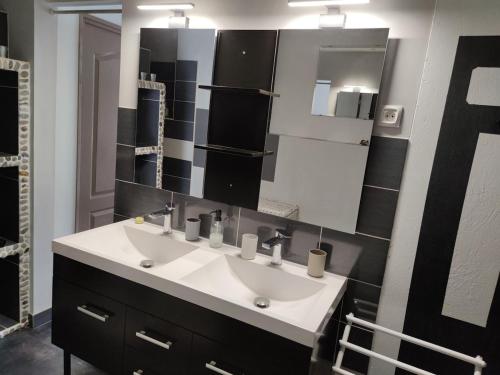 a bathroom with two sinks and a large mirror at Quiet house, sun and pool in Le Thor