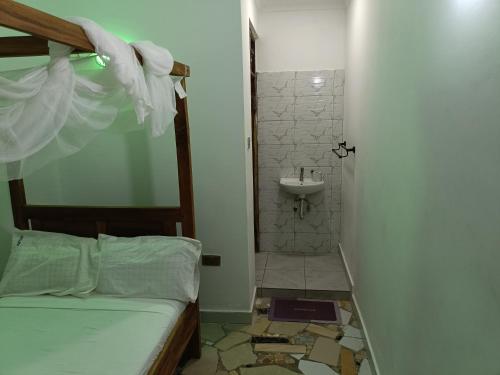 a bathroom with a bed and a shower and a sink at Escape Retreats in Diani Beach