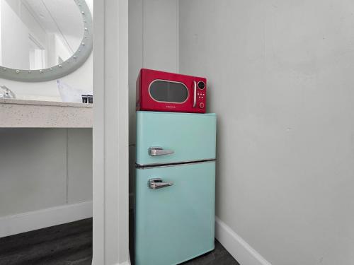 a red microwave sitting on top of an old refrigerator at CRYSTAL PALACE RESORT in Bolivar Peninsula