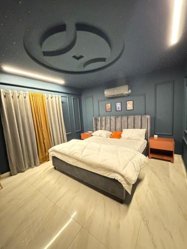 a bedroom with a large bed and a ceiling with aucer at Moonlit Cinema Suite in Lahore