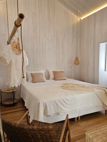 a bedroom with a large white bed in a room at Grão de Areia - Mosteiros - 50m da praia - piscina privada in Mosteiros