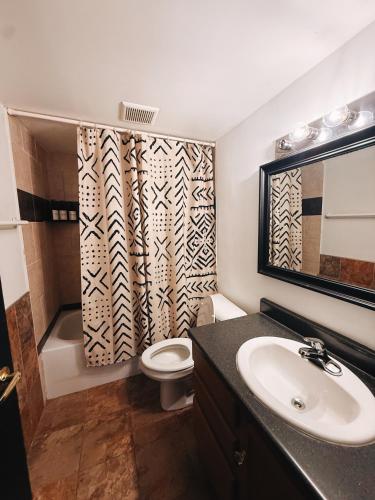 a bathroom with a sink and a toilet and a mirror at 420 Friendly SKYLINE view Downtown Loft FREE Parking in Detroit