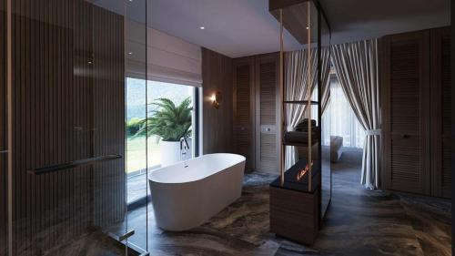ein Badezimmer mit Badewanne und großem Fenster in der Unterkunft Glory Resort in Baile Felix