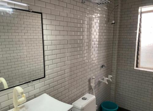 a white bathroom with a shower and a toilet at Centre point jawai in Bīsalpur