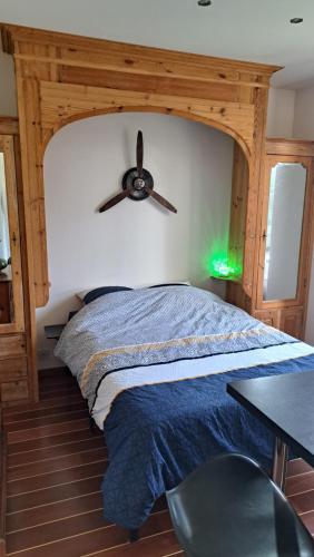 a bedroom with a large bed with a ceiling fan at Studio à 70m des flots in Trébeurden