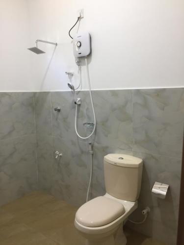 a bathroom with a toilet and a shower at Mimi's Cottage in Udawalawe