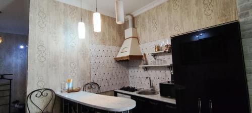 a kitchen with a counter and a sink in it at Hidden Rooms Freedom Square in Tbilisi City