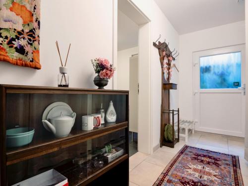 a living room with a shelf with dishes on it at Beim Thöny - schönes Apartment mit privatem Zugang in Utting am Ammersee