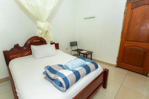 a bedroom with a bed with a striped blanket on it at Admiral Hotel and Spa Kampala in Kampala
