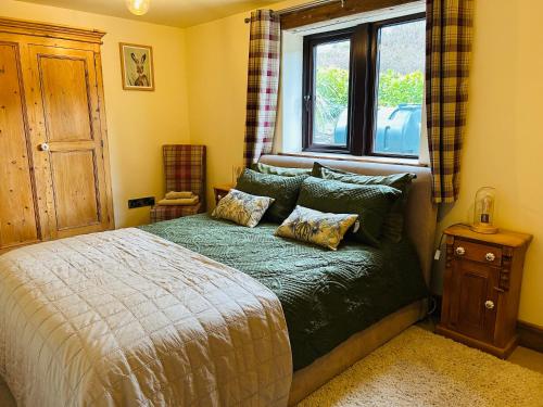 a bedroom with a large bed with a window at Pingle Nook Barn on the Farm - Denby Dale in Huddersfield