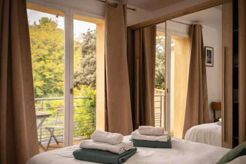 a room with two beds and a window with a balcony at Villa Pierre Blanche le calme a 5mn du centre ville in Nîmes