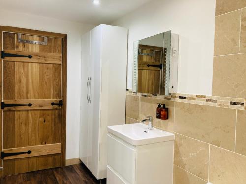 a bathroom with a sink and a mirror at Pingle Nook Barn on the Farm - Denby Dale in Huddersfield