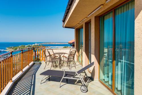 a balcony with chairs and tables and a view of the ocean at Kalithea Family Hotel in Sozopol