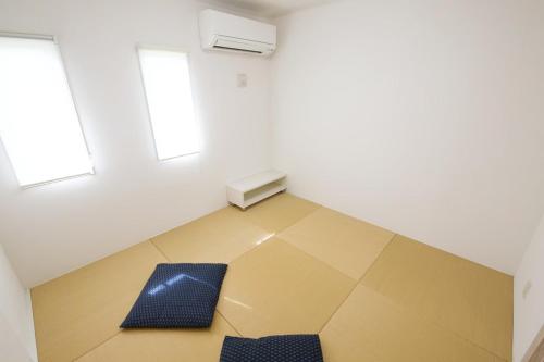 an empty room with two chairs and two windows at Maison Haan Motobu in Motobu