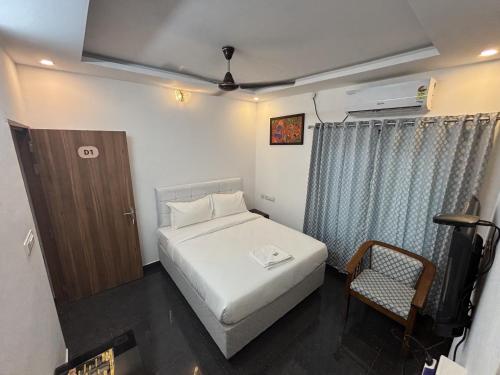 a small bedroom with a bed and a chair at MIRACLE Inn in Alwaye