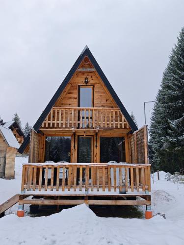 a log cabin with a deck in the snow at Brvnara Panda Tara in Rača