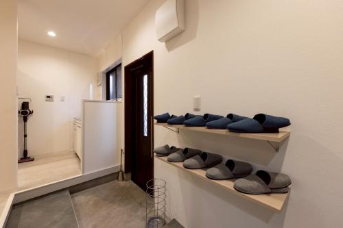 a room with shelves with blue pillows and a refrigerator at Waen Tenma in Osaka