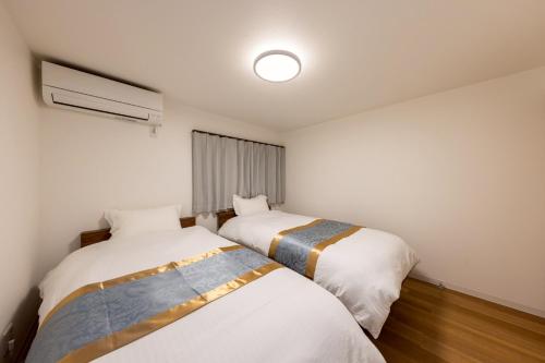 two beds in a small room with a window at Waen Tenma in Osaka