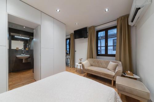 a bedroom with a white bed and a couch at Apartmán Daniel in Levoča