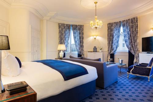 a bedroom with a king sized bed and a couch at Le Royal Hotel Lyon - MGallery Collection in Lyon