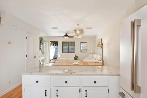 a kitchen with white cabinets and a living room at Villa Leo in Saint Simons Island
