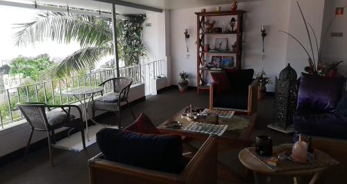 a living room with chairs and tables and a balcony at Casa Pico Musica in Funchal