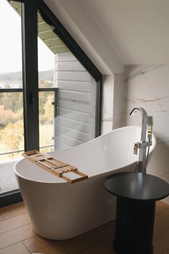 a large bath tub in a bathroom with a window at VILLA nad JEZIOREM in Mucharz
