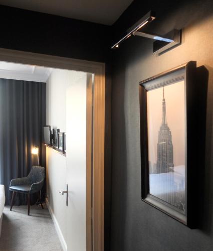 a room with a mirror and a room with a city at Hôtel Londres et New York - Teritoria in Paris