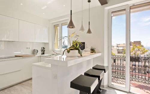 a kitchen with white cabinets and a large window at Duplex ForVille in Cannes