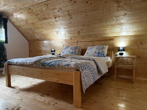 a bedroom with a bed with a wooden wall at Kuća Sunny Rudnik in Rudnik