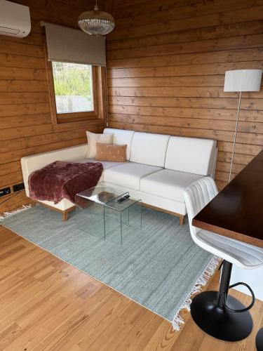 a living room with a white couch and a table at Sunset Eco Shelter 4 in Ponta do Pargo