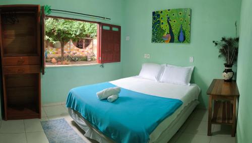 a bedroom with a bed with a teddy bear on it at Caju Hostel in Alter do Chao