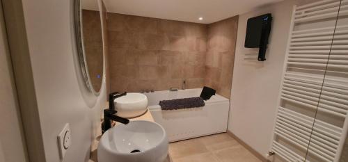 a bathroom with a sink and a toilet and a tub at La maison de Morgane in Tourmont