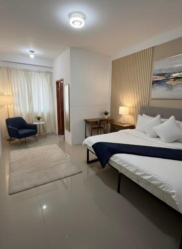a bedroom with a bed and a desk and a chair at La Residencia Homestay in Digos