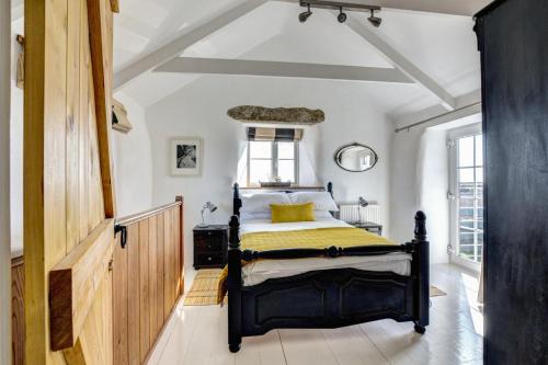 a bedroom with a bed with a yellow and black comforter at 3 Bed in Sennen oc-thbyre in Sennen