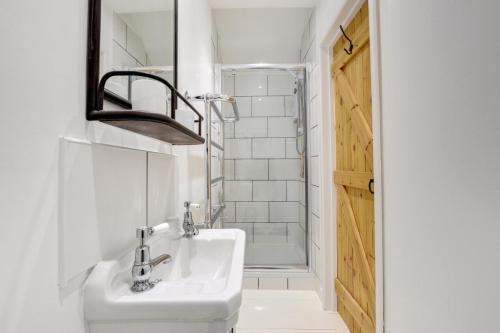 a white bathroom with a sink and a shower at 3 Bed in Sennen oc-thbyre in Sennen