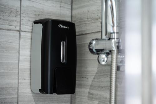 a black soap dispenser on a bathroom door at Spacious Central Nottingham House in Nottingham