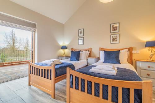 two beds in a bedroom with a balcony at 4 Bed in Heveningham oc-w29036 in Heveningham