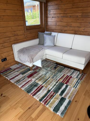 a white couch sitting on top of a rug at Sunset Eco Shelter 3 in Ponta do Pargo