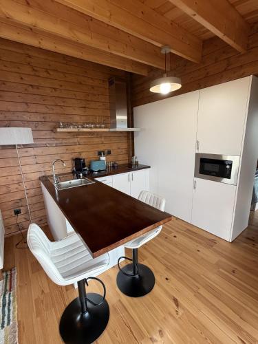 a kitchen with a table and two white chairs at Sunset Eco Shelter 3 in Ponta do Pargo