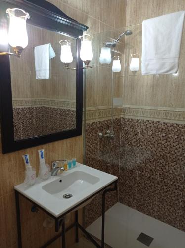 a bathroom with a sink and a shower with a mirror at Hotel-Restaurante La Sima in Castillo de Garcimuñoz