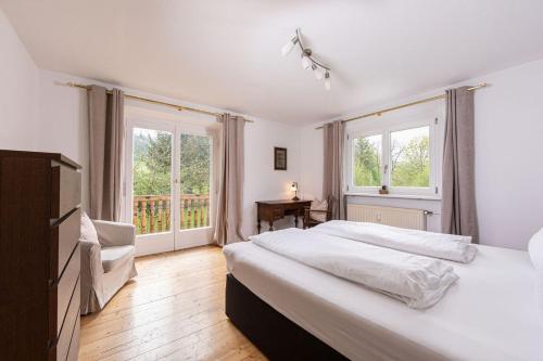 a bedroom with a large white bed and windows at Villa Marga Ferienwohnung Jenner in Schönau am Königssee