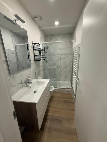 a white bathroom with a sink and a shower at La Divina Commedia in Florence