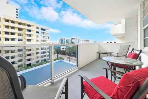 a balcony with a table and chairs and a pool at Miami Beach Studio with shared Heated Pool & Gym in Miami Beach