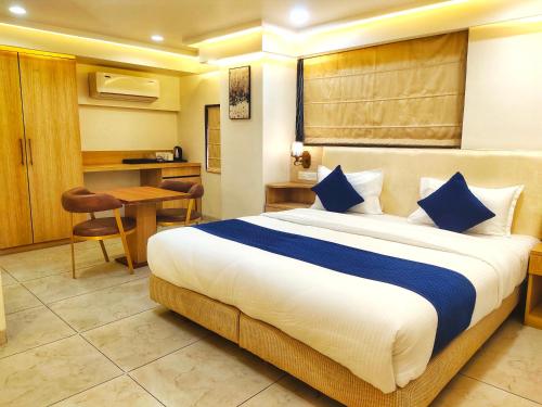a hotel room with a large bed and a desk at All seasons boutique rooms in Pune