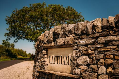 a stone wall with a sign on the side of a road at Laythams Holiday Lets Retreat in Slaidburn